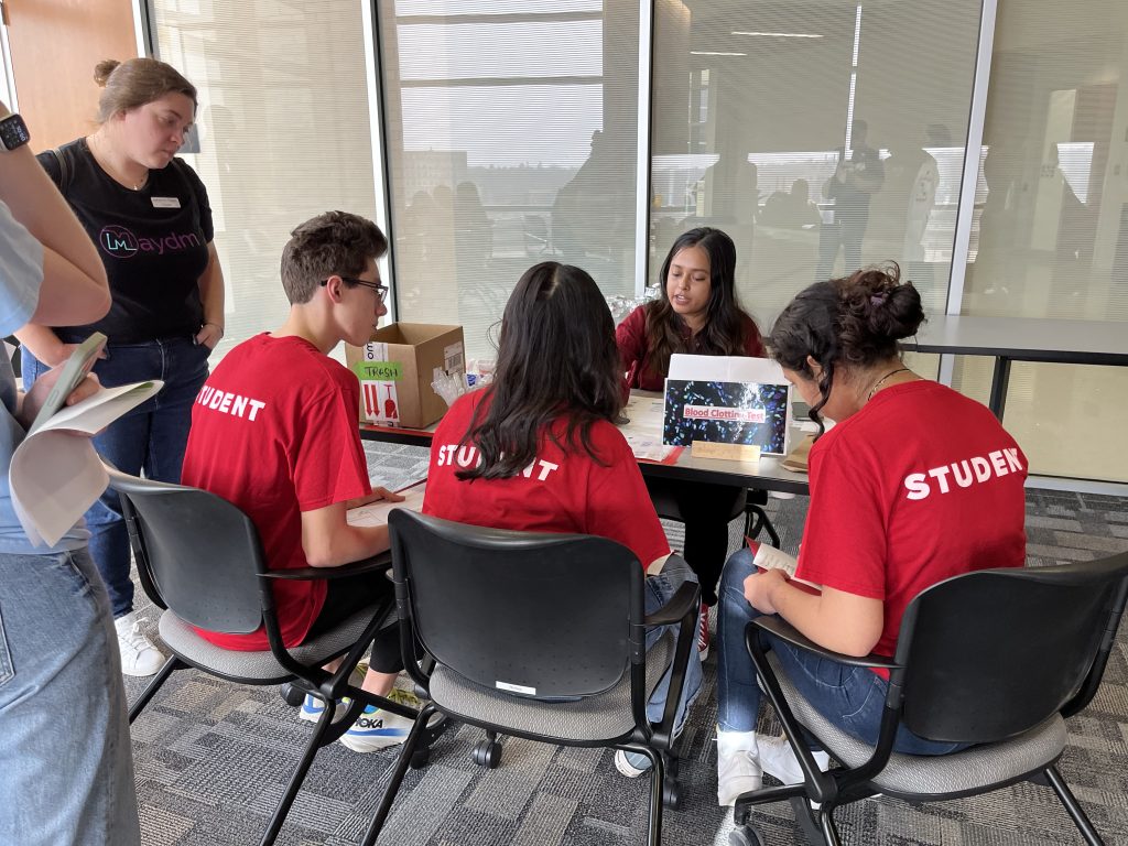 Churpek lab members show off their skills while teaching high school students associated with the HOPE program.