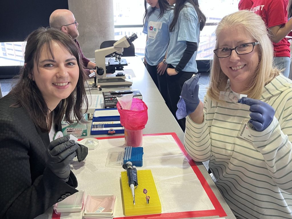 Sarah and Mary show off their "blood" smears in a Health Occupations and Professions Exploration (HOPE) event where high school students learned from the Churpek lab participating in a hands-on mystery event.